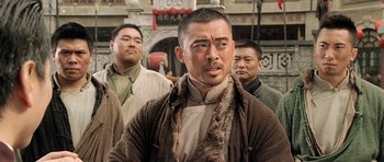 Movie still from “Ip Man” (2008), directed by Wilson Yip – A group of men standing next to each other; Close Up shot, Over the shoulder angle