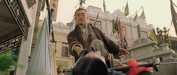 Movie still from “Ip Man” (2008), directed by Wilson Yip – A man in a brown jacket is holding a man's head; Medium shot, Low angle