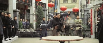Movie still from “Ip Man” (2008), directed by Wilson Yip – A man flying through the air on top of a table; Wide shot, Low angle