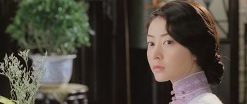 Movie still from “Ip Man” (2008), directed by Wilson Yip – A young woman is looking into the camera; Close Up shot, Over the shoulder angle