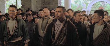 Movie still from “Ip Man” (2008), directed by Wilson Yip – A group of men standing next to each other in front of a brick wall; Medium shot, Over the shoulder angle