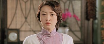 Movie still from “Ip Man” (2008), directed by Wilson Yip – A young woman in a pink shirt and a pink dress; Close Up shot, Over the shoulder angle