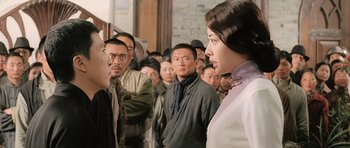 Movie still from “Ip Man” (2008), directed by Wilson Yip – A group of people standing in front of a brick wall; Medium shot, Over the shoulder angle