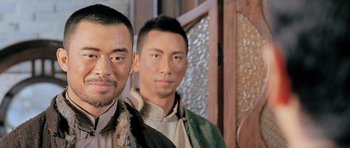 Movie still from “Ip Man” (2008), directed by Wilson Yip – Two men standing next to each other in front of a wall; Close Up shot, Low angle