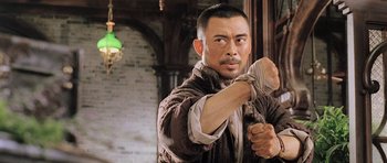 Movie still from “Ip Man” (2008), directed by Wilson Yip – A man in a brown jacket is holding a knife; Close Up shot, Low angle