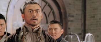 Movie still from “Ip Man” (2008), directed by Wilson Yip – A man with a shaved head and a man with a shaved head and a beard; Close Up shot, Over the shoulder angle