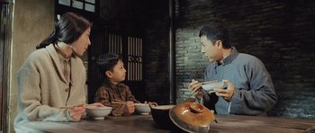 Movie still from “Ip Man” (2008), directed by Wilson Yip – Two young boys sitting at a wooden table; Medium shot, High angle