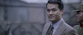 Movie still from “Ip Man” (2008), directed by Wilson Yip – A person wearing a suit and tie; Close Up shot, Over the shoulder angle