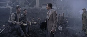 A group of people sitting in the dirt