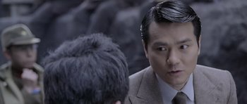 Movie still from “Ip Man” (2008), directed by Wilson Yip – A person wearing a suit and tie; Close Up shot, Over the shoulder angle
