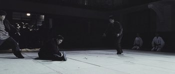 Two men are sitting on the ground in a dark room