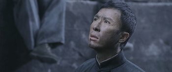 Movie still from “Ip Man” (2008), directed by Wilson Yip – An asian man looking up into the air; Close Up shot, Low angle