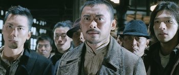 Movie still from “Ip Man” (2008), directed by Wilson Yip – A group of men standing next to each other in a crowd; Close Up shot, Low angle