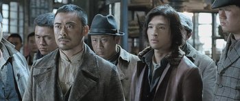 Movie still from “Ip Man” (2008), directed by Wilson Yip – A group of men standing next to each other in a room; Medium shot, Low angle