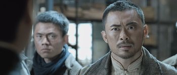 Movie still from “Ip Man” (2008), directed by Wilson Yip – Two men standing next to each other in front of a window; Close Up shot, Low angle