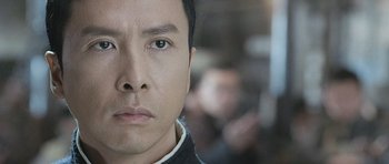 Movie still from “Ip Man” (2008), directed by Wilson Yip – A man's face in a black shirt; Close Up shot, Low angle