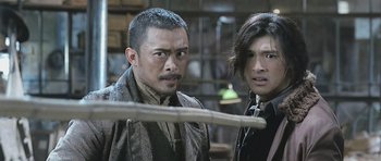 Movie still from “Ip Man” (2008), directed by Wilson Yip – Two men standing next to each other in a room; Close Up shot, Over the shoulder angle