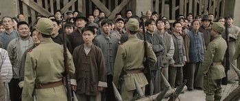 Movie still from “Ip Man” (2008), directed by Wilson Yip – A group of men standing next to each other holding guns; Wide shot, High angle