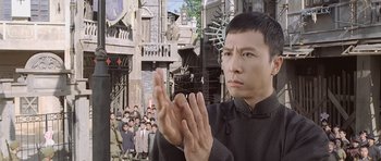 Movie still from “Ip Man” (2008), directed by Wilson Yip – A man clapping his hands in front of a group of people; Medium shot, Low angle