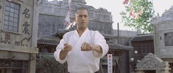 Movie still from “Ip Man” (2008), directed by Wilson Yip – A man in a karate outfit is practicing his moves; Medium shot, Low angle