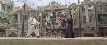Movie still from “Ip Man” (2008), directed by Wilson Yip – Two men are practicing martial arts in front of a building; Wide shot, Low angle