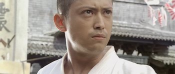 Movie still from “Ip Man” (2008), directed by Wilson Yip – A person wearing a karate uniform; Close Up shot, Low angle