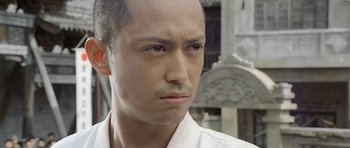 Movie still from “Ip Man” (2008), directed by Wilson Yip – A person wearing a white shirt; Close Up shot, Low angle