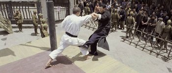 Movie still from “Ip Man” (2008), directed by Wilson Yip – Two men are practicing martial arts on the sidewalk; Wide shot, High angle