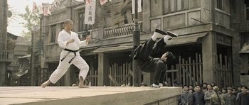 Movie still from “Ip Man” (2008), directed by Wilson Yip – Two men are performing martial arts on a city street; Wide shot, Low angle