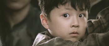 Movie still from “Ip Man” (2008), directed by Wilson Yip – A child with a scarf around his neck; Close Up shot, Over the shoulder angle