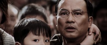 Movie still from “Ip Man 2” (2010), directed by Wilson Yip – An older man and a young boy are looking at the camera; Close Up shot, Over the shoulder angle
