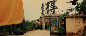 Movie still from “Ip Man 2” (2010), directed by Wilson Yip – An asian restaurant with a man standing in front of the entrance; Extreme Wide shot, Low angle