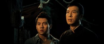 Movie still from “Ip Man 2” (2010), directed by Wilson Yip – Two men standing next to each other in a dark room; Close Up shot, Low angle
