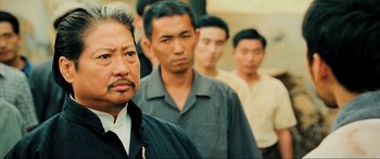 Movie still from “Ip Man 2” (2010), directed by Wilson Yip – A group of men standing next to each other in a line; Close Up shot, Over the shoulder angle