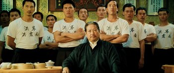 Movie still from “Ip Man 2” (2010), directed by Wilson Yip – A group of men standing next to each other in a room; Medium shot, Low angle