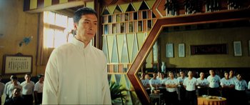 Movie still from “Ip Man 2” (2010), directed by Wilson Yip – A man standing in front of a group of people in a room; Medium shot, Low angle