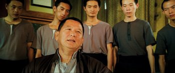 Movie still from “Ip Man 2” (2010), directed by Wilson Yip – A group of men standing next to each other in a room; Close Up shot, Over the shoulder angle