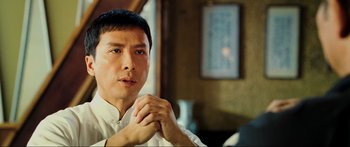 Movie still from “Ip Man 2” (2010), directed by Wilson Yip – A person holding their hands together; Close Up shot, Low angle