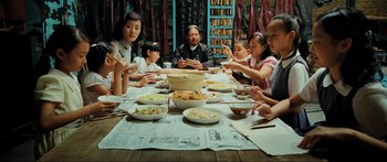 Movie still from “Ip Man 2” (2010), directed by Wilson Yip – A group of people sitting around a table eating food; Medium shot, High angle