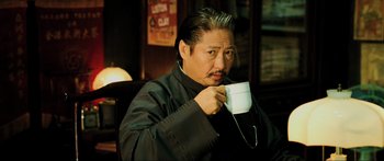 Movie still from “Ip Man 2” (2010), directed by Wilson Yip – A man in a black shirt is holding a white cup; Close Up shot, Low angle