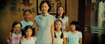 Movie still from “Ip Man 2” (2010), directed by Wilson Yip – A group of people standing next to each other in a room; Medium shot, Low angle
