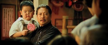 Movie still from “Ip Man 2” (2010), directed by Wilson Yip – A man holding a lollipop in his mouth; Close Up shot, Over the shoulder angle