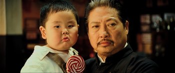 Movie still from “Ip Man 2” (2010), directed by Wilson Yip – A man and a child with a lollipop; Close Up shot, High angle
