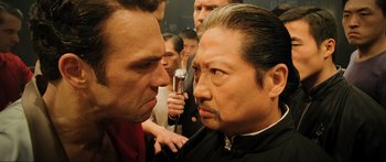 Movie still from “Ip Man 2” (2010), directed by Wilson Yip – Two men are facing each other in front of a crowd; Close Up shot, Over the shoulder angle
