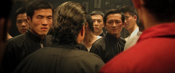 Movie still from “Ip Man 2” (2010), directed by Wilson Yip – A group of men standing next to each other in front of a mirror; Medium shot, Over the shoulder angle