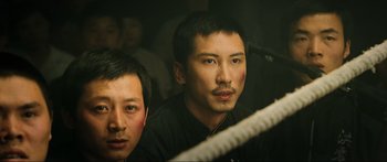 Movie still from “Ip Man 2” (2010), directed by Wilson Yip – Two asian men in a boxing ring looking at the camera; Close Up shot, Over the shoulder angle