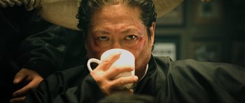 Movie still from “Ip Man 2” (2010), directed by Wilson Yip – A man drinking from a white mug with a red spot on his face; Close Up shot, Low angle