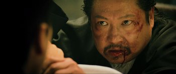 Movie still from “Ip Man 2” (2010), directed by Wilson Yip – A man with blood all over his face; Extreme Close Up shot, Over the shoulder angle