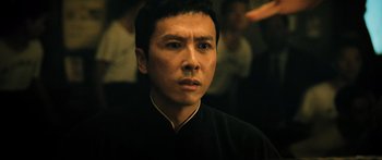 Movie still from “Ip Man 2” (2010), directed by Wilson Yip – A person wearing a black shirt; Close Up shot, Over the shoulder angle