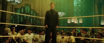 Movie still from “Ip Man 2” (2010), directed by Wilson Yip – A man standing in a boxing ring in front of a group of people; Wide shot, Low angle
